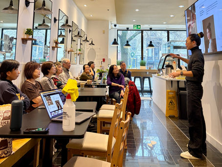 Volunteers gathered for training at Café le Chemin before opening, listening to instruction in the space