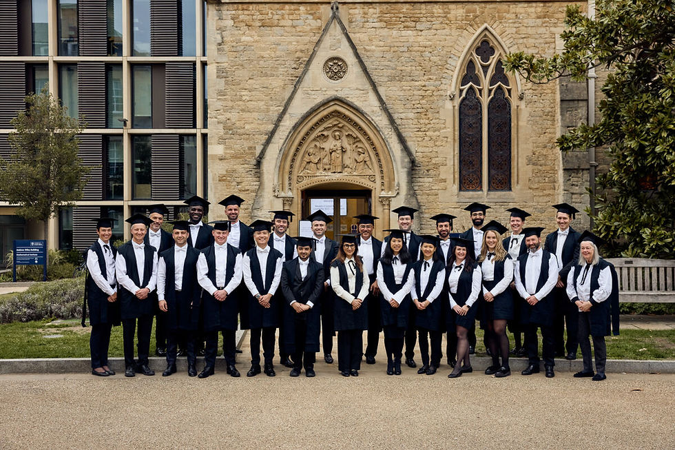 Group photo of Oxford Global Health Leadership Programme participants in academic gowns standing outside a historic stone building with arched doorway and stained glass window.