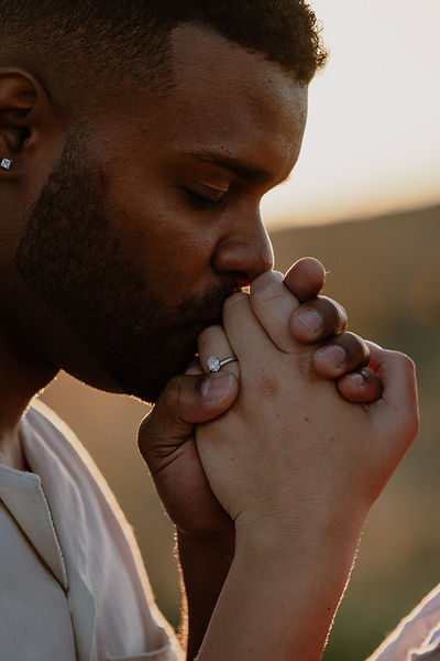 Engaged couple kissing ring on hand
