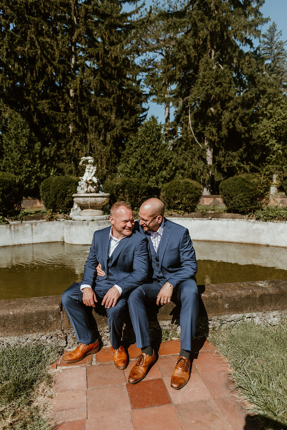 A male couple sitting together snugly and laughing