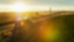 Semi-truck driving at sunset