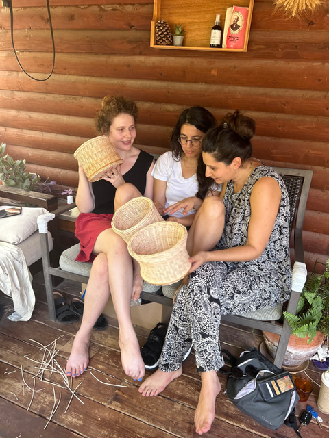 שלוש אחיות בסדנא פרטית בוחנות את הסלים שקלעו כל אחת מהן
