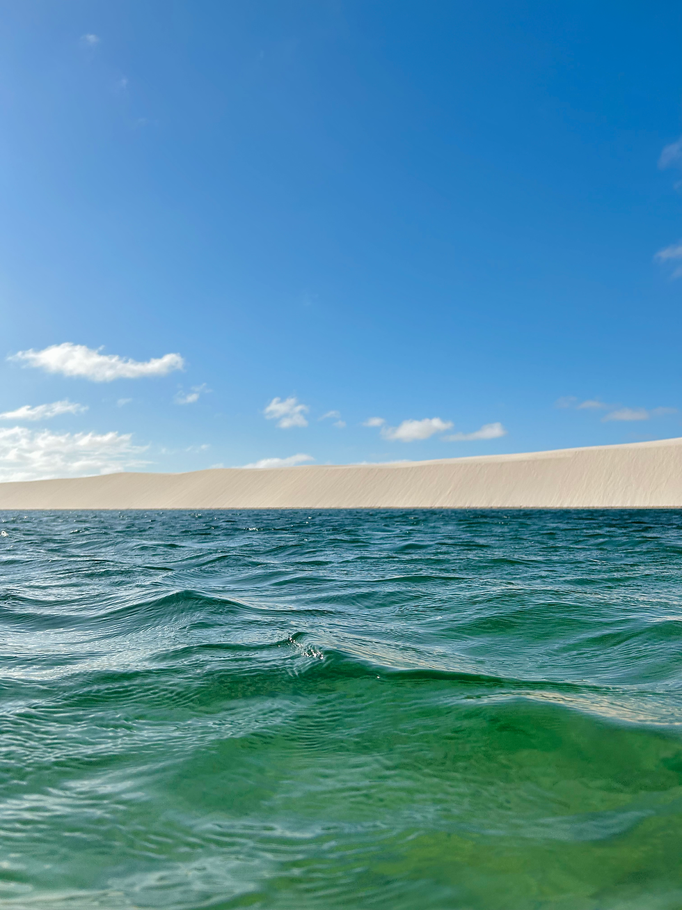 a lagoon in the middle of the desert with crystal-clear water.