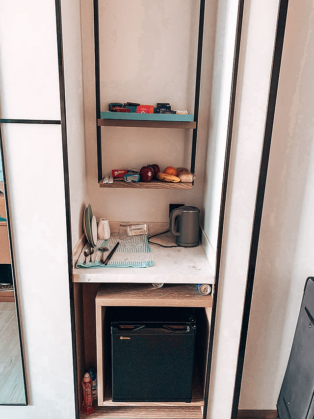 hote room kitchenette with kettle, dishes and fruit shelf