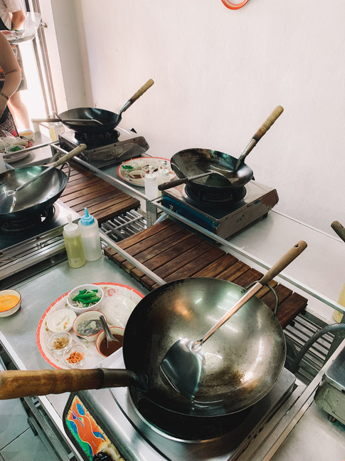 wok pans on individual hobs layed out on table for bangkok cooking class