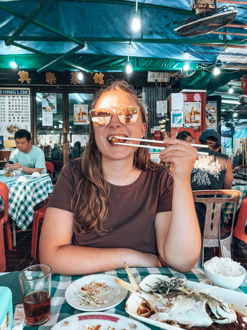 girl with sunglasses eating with chopsticks