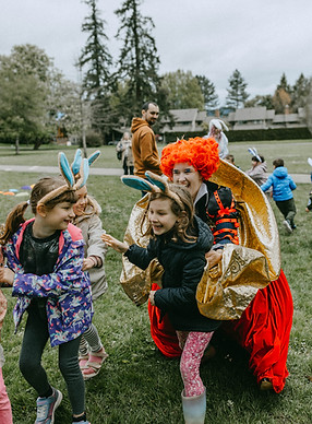 Kids enjoying an Alice in Wonderland themed birthday party with Queen of Hearts character at a park in Seattle