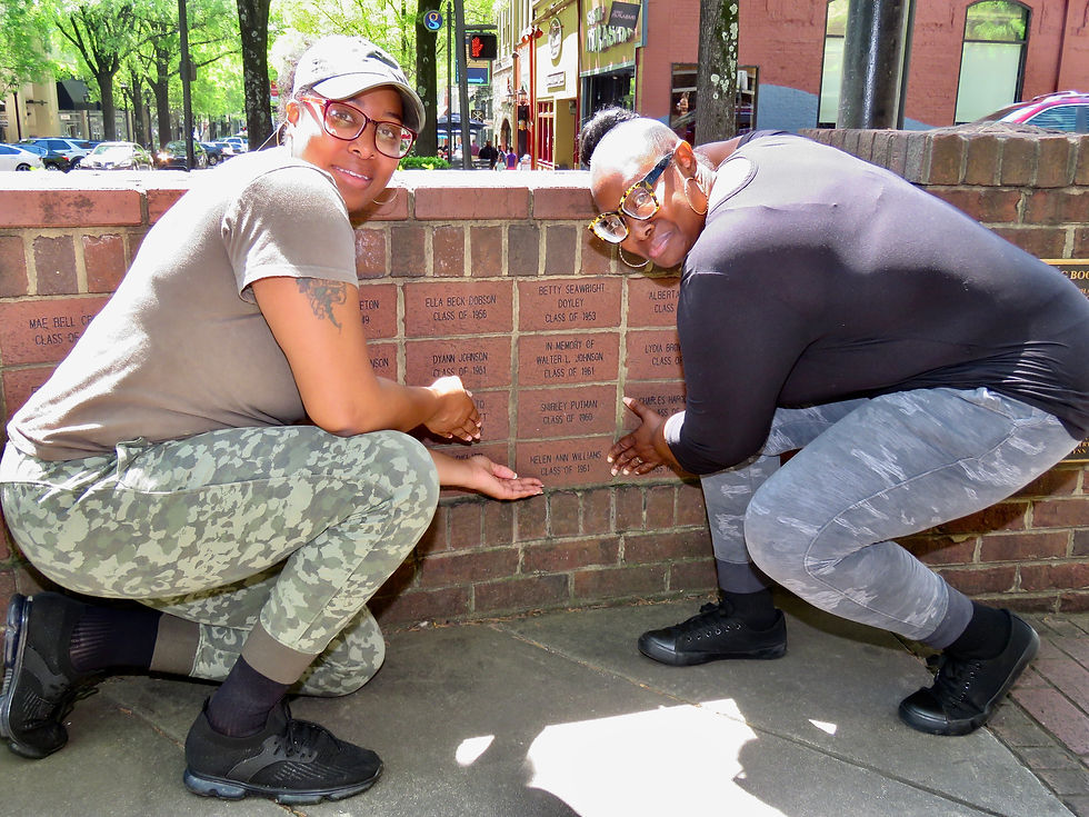 DAUGHTER AND GRANDDAUGHTER EXAMINE THE NAME OF HELEN ANN WILLIAMS ON MEMORIAL