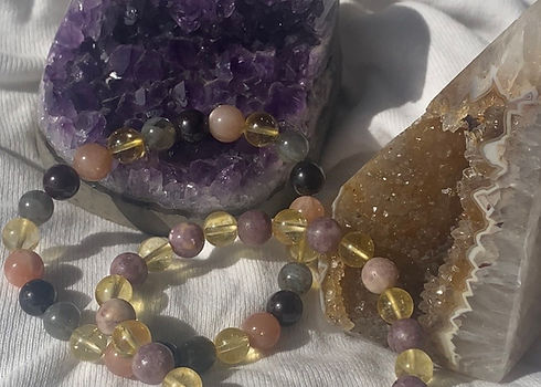 Handmade crystal bracelets resting on amethyst and citrine