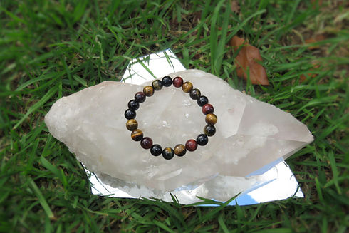 Tigers eye and obsidian beaded bracelet on a large clear crystal