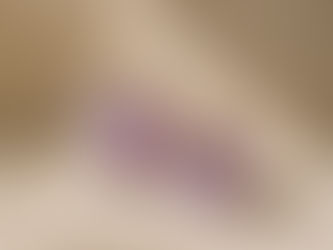 Two purple amethyst crystals on a beige surface, lit by soft sunlight with dried flowers and gentle shadows.