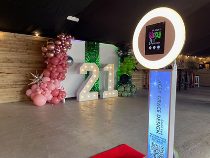 21st Birthday Decor with personalised backdrop, green shimmer wall, light up numbers, pink and green garlands and selfie pod