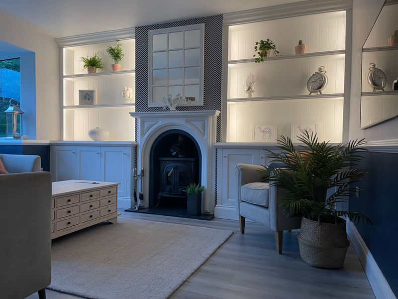 A white alcove unit with built-in cupboards and integrated lighting for practicality and ambiance. The lighting system includes touch-sensitive controls for adjustable brightness levels. Custom-built cupboards offer maximum storage, finished with stylish glass handles.
