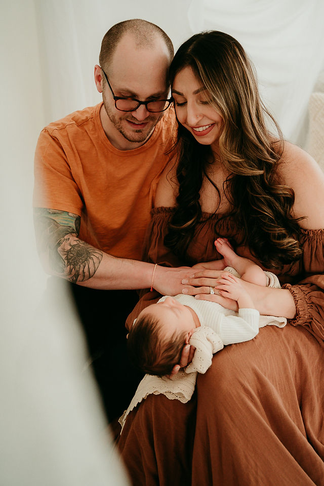 Mom and Dad holding newborn baby in Baltimore photography studio 