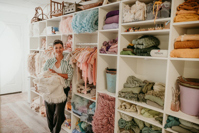 Baltimore newborn photographer studio shelves with soft newborn wraps and blankets in Cockeysville, MD