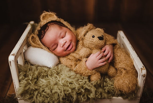Newborn baby smiling for a photo in a Baltimore Maryland newborn studio