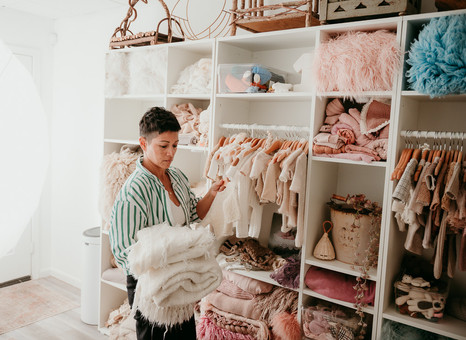Mom looking at cute outfits for her newborn photoshoot in a fully stocked newborn photography studio in Baltimore Maryland