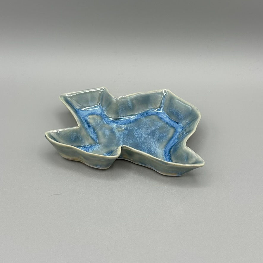 Handcrafted ceramic dish in the shape of Texas, featuring a soft blue glaze.