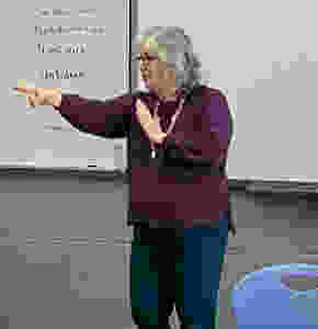 Woman signing in front of a whiteboard