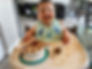 smiling-baby-sits-in-high-chair-eating