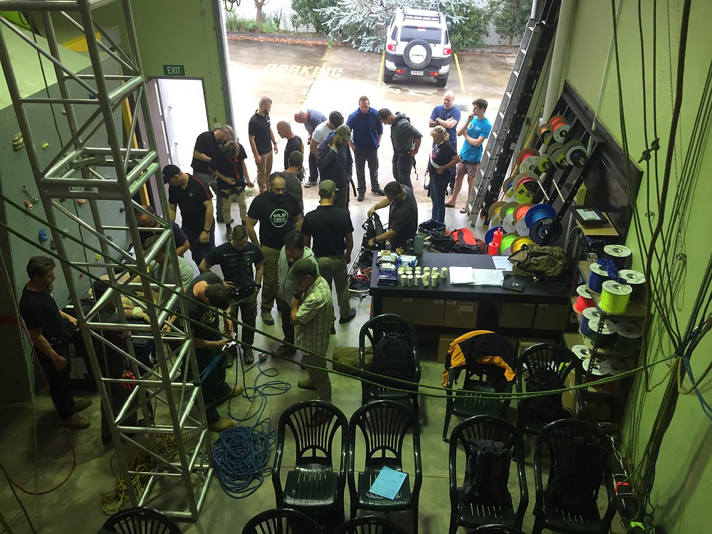 A group of students in a rope-access training facility in the NSW Blue Mountains practise fitting climbing harnesses and rope control devices