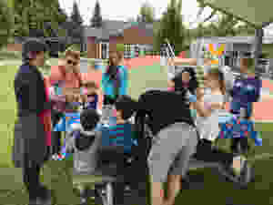 A group of kids sit at a picnic table for an art class.