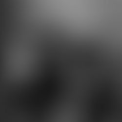 HAYDEL with guitar in hands, laying on couch