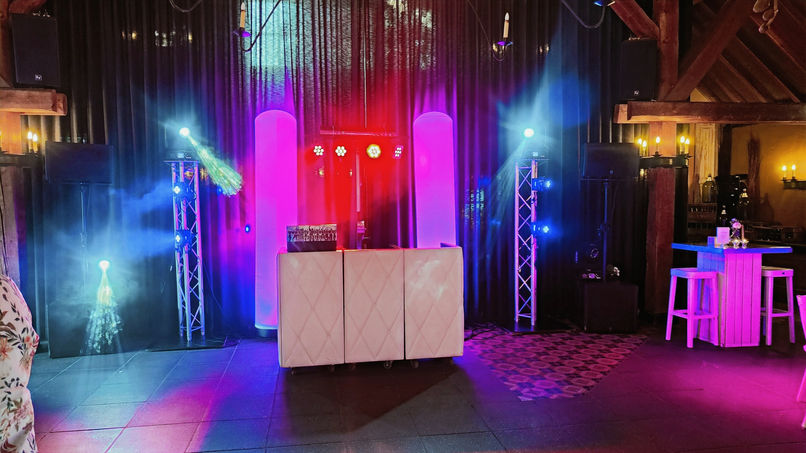 Party-Discoshow apparatuur op podium met discoverlichting in een feestzaal.