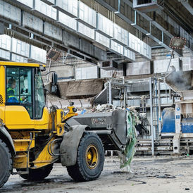 Een loader met afval in een recyclingcentrale