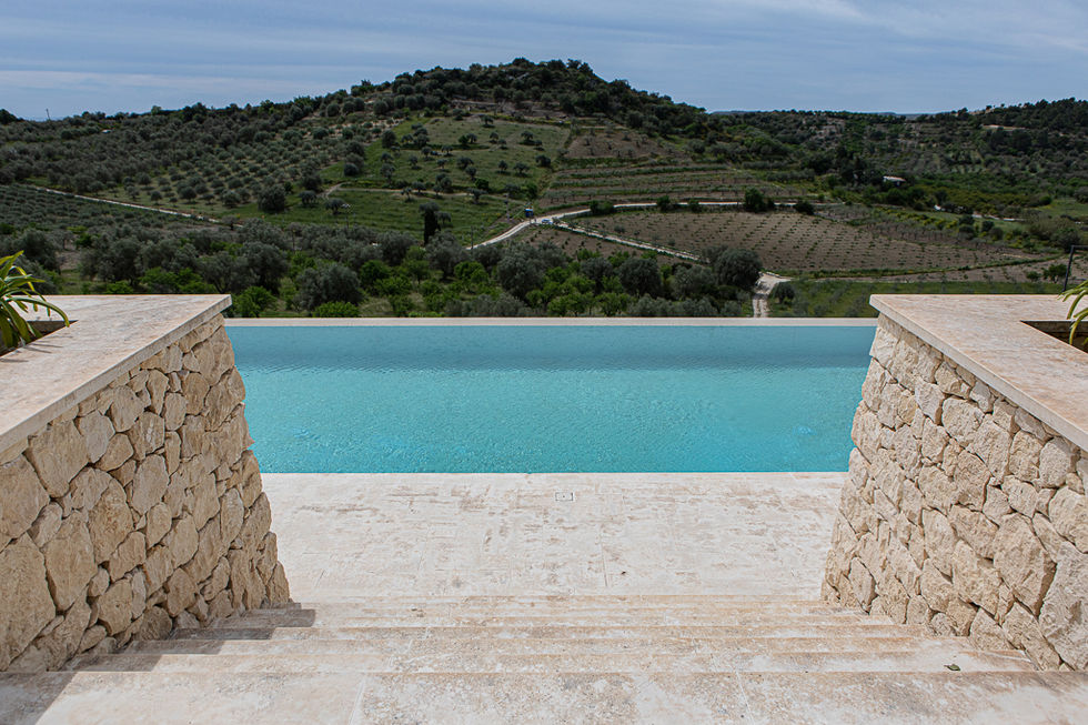 scale in pietra di Modica e piscina a sbalzo su colline