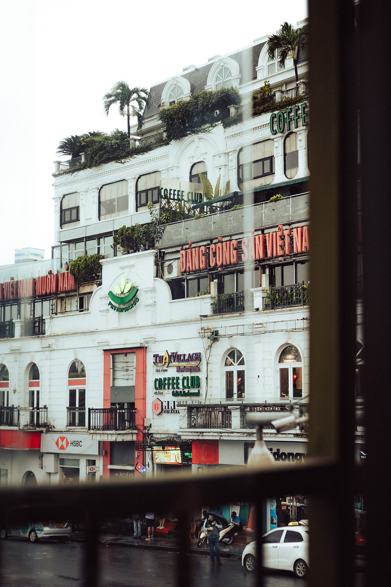 White buildings with Vietnamese café signs and billboards in Hanoi.