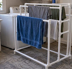 Freestanding PVC drying rack in laundry room.jpeg
