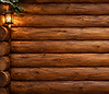 Glowing lantern on a log cabin wall.