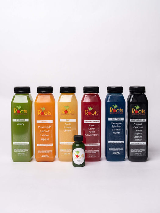 Fresh juices bottled up on a white backdrop