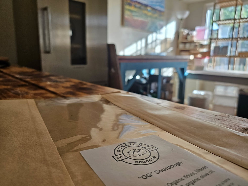 Eye-level view of a cozy microbakery counter displaying freshly baked artisan breads and pastries