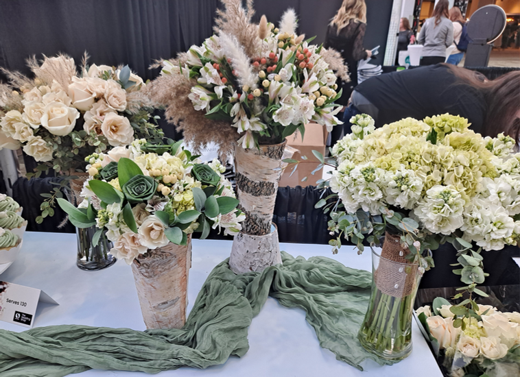 Four of Safeway floral's wedding bouquets, displayed in birch-covered vases