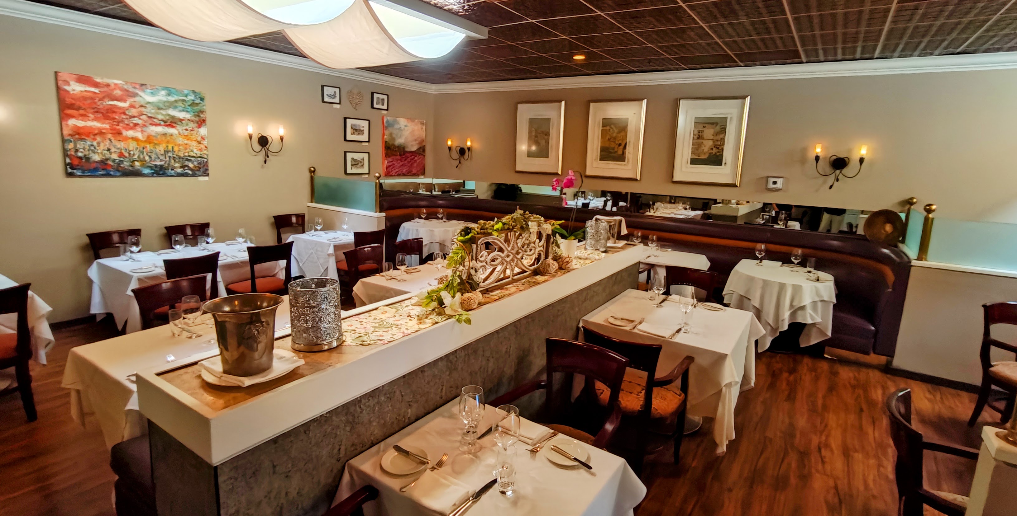 An elegant fine dining room set with white linens and crystal glassware for a special event.