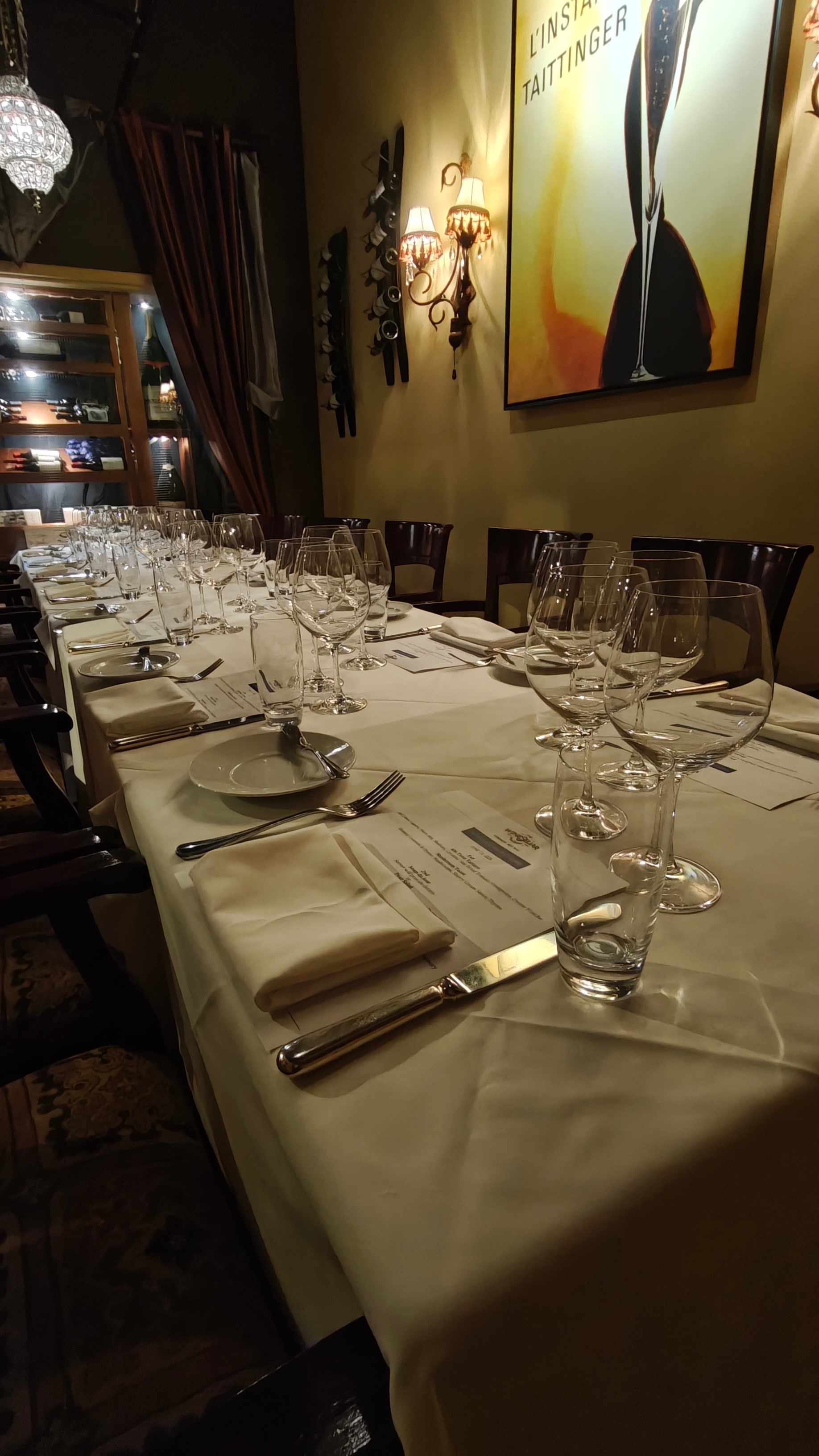 A cozy and intimate private dining room with a single long table and elegant lighting.