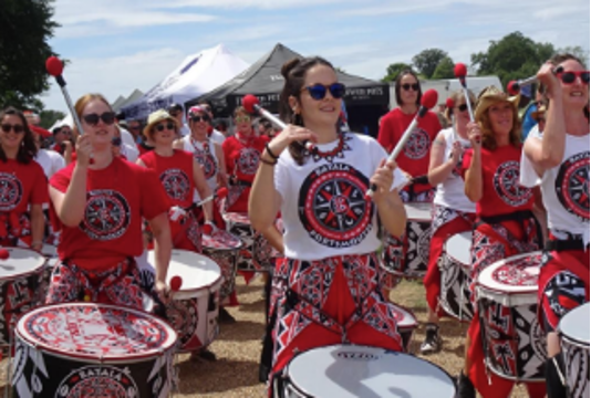 A carnival band walking and all playing the drums