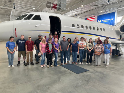 students standing in front of a plane