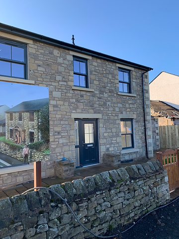 New stone house in a housing development, exemplifying modern residential architecture financed through LivFinance's development finance services.