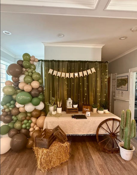 Western party decor with Memory lane banner and balloons. decorated with wooden wheels, wooden boxes, and cactus.