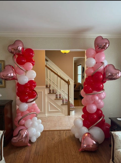 Red, pink, and white balloon columns with heart balloons