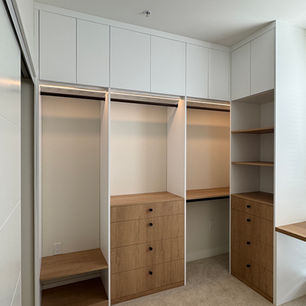 Minimalist wooden closet with open shelves and drawers.