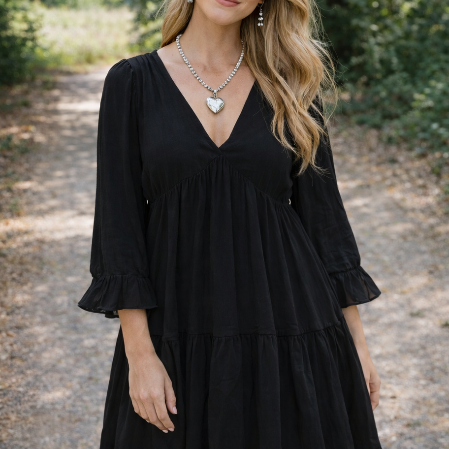 sterling silver bead necklace with heart pendant shown on model dressed in black dress
