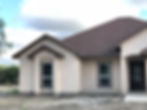 Newly built home with tan walls and dark roof