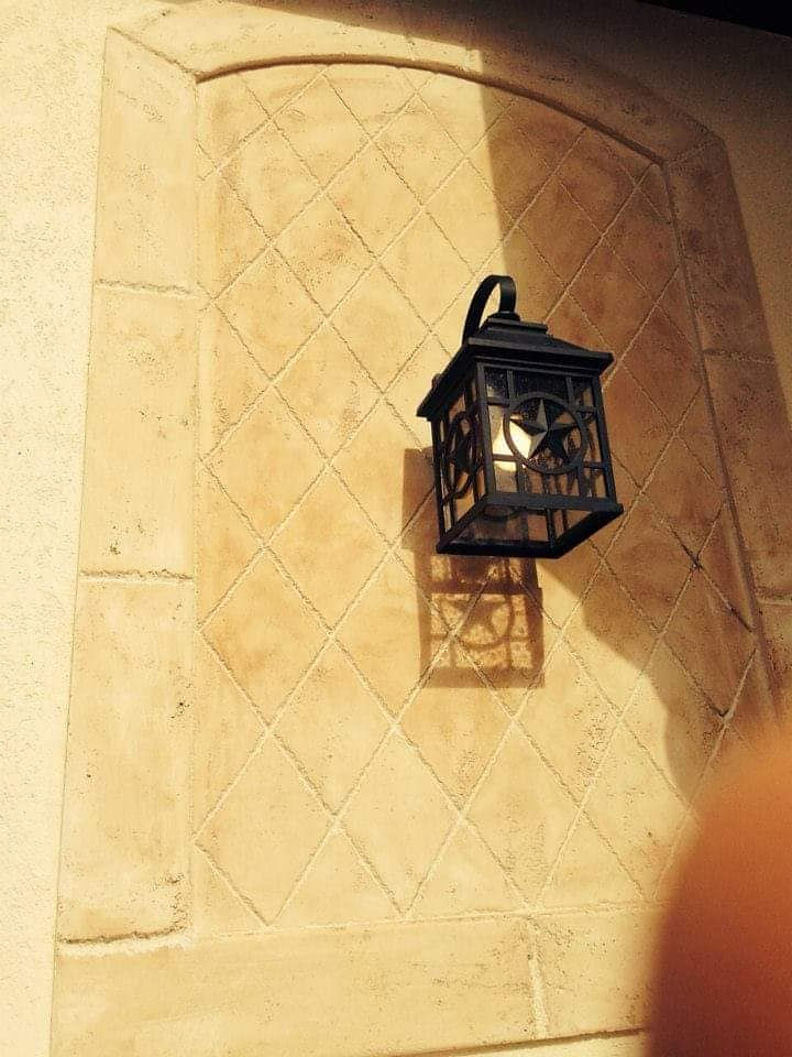 Ornate dark lantern on patterned stone wall