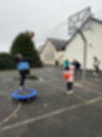Children playing basketball and on trampoline at school