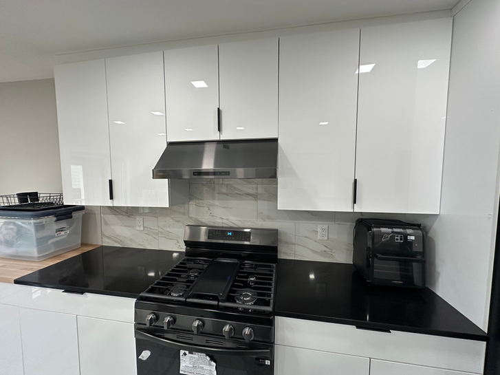 Kitchen remodel in Ridgewood, NJ with white cabinets, quartz island, and stainless-steel range.