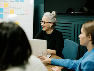 CX leader confidently engaging with cross-functional team during a strategic planning session, highlighting collaborative leadership.